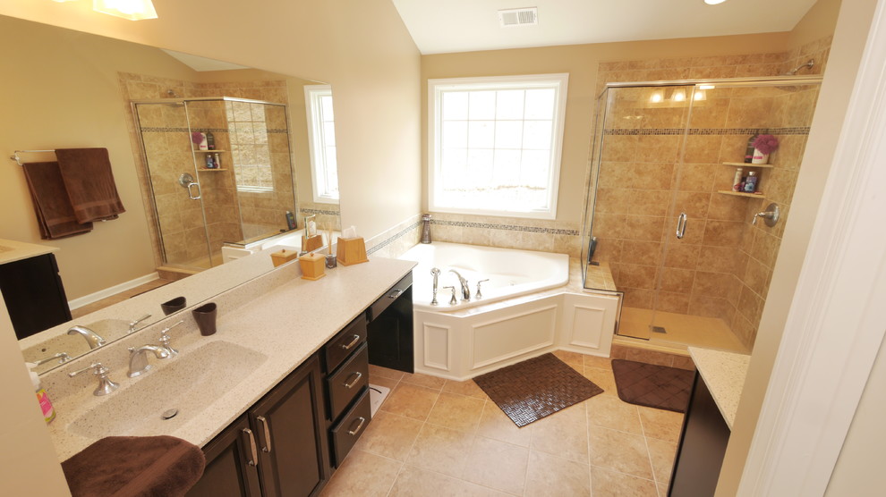 Cette photo montre une salle de bain principale chic en bois foncé avec un placard avec porte à panneau surélevé, une baignoire d'angle, un carrelage beige, des carreaux de céramique et un sol en carrelage de céramique.