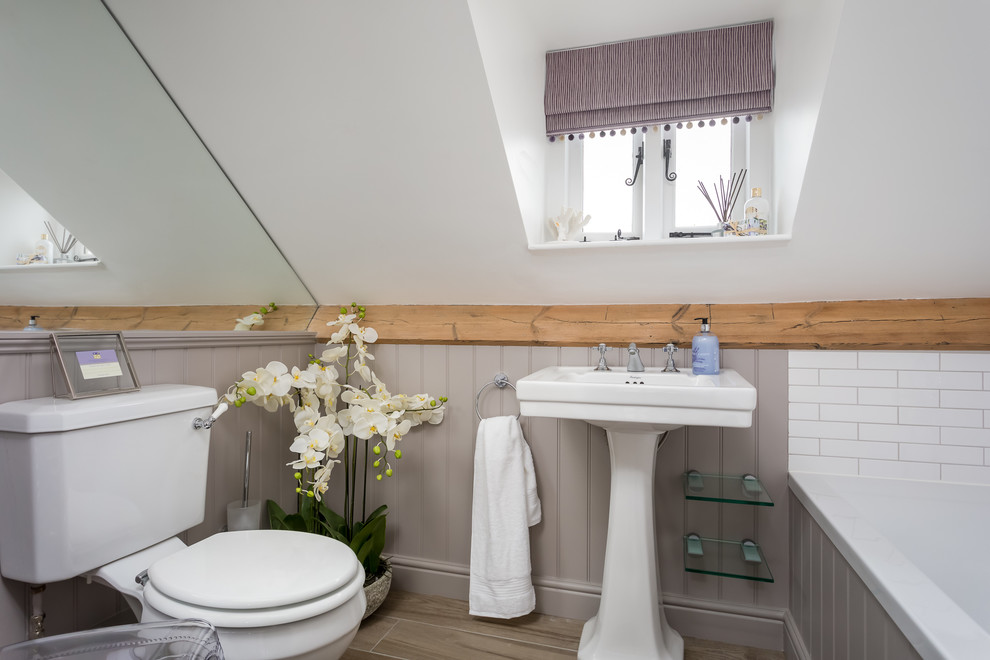 На фото: маленькая главная ванная комната в стиле кантри с ванной в нише, унитазом-моноблоком, белой плиткой, белыми стенами и консольной раковиной для на участке и в саду