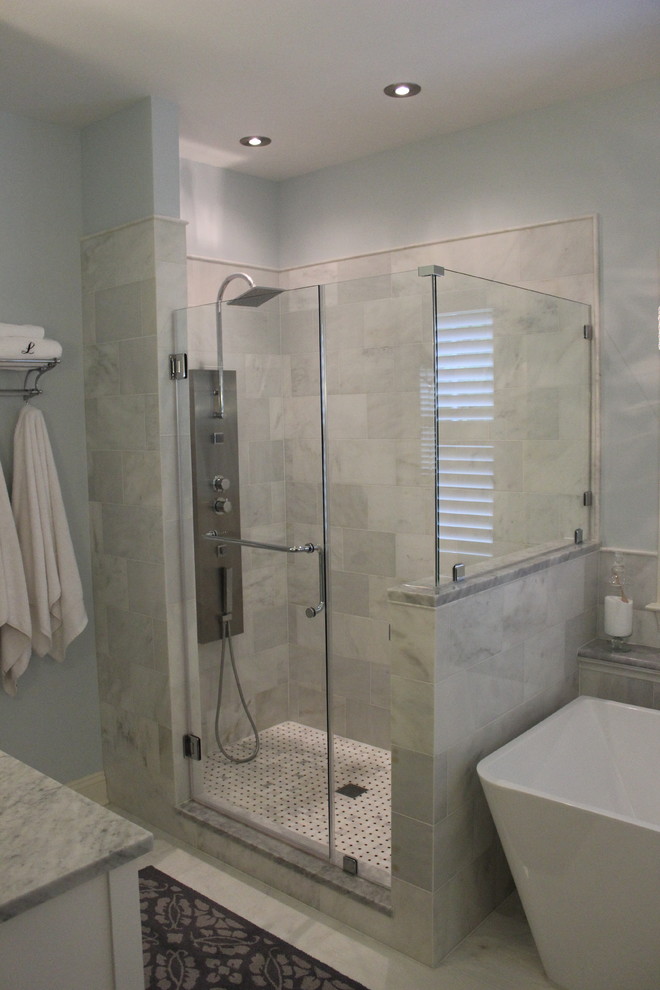 Inredning av ett klassiskt mycket stort en-suite badrum, med luckor med infälld panel, vita skåp, marmorbänkskiva, ett fristående badkar, en hörndusch, vit kakel, keramikplattor, blå väggar och klinkergolv i keramik
