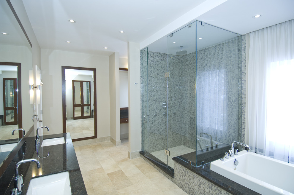 Réalisation d'une douche en alcôve design avec un lavabo encastré, une baignoire posée, un carrelage beige et mosaïque.