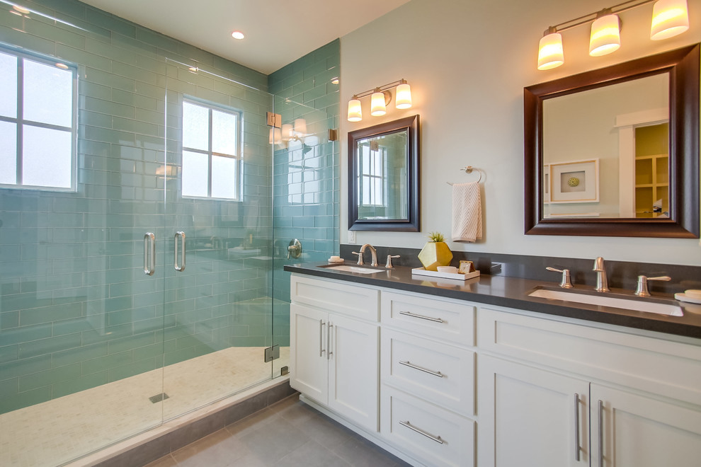 Esempio di una stanza da bagno padronale stile marino di medie dimensioni con ante in stile shaker, ante bianche, doccia doppia, piastrelle blu, piastrelle di vetro, pareti beige, pavimento in gres porcellanato, lavabo sottopiano e top in superficie solida