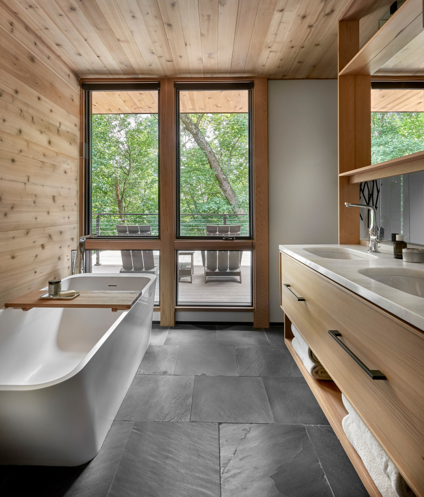 Example of a mid-sized mountain style master blue tile and terra-cotta tile slate floor, black floor, double-sink, wood ceiling and wood wall bathroom design in Chicago with flat-panel cabinets, light wood cabinets, a one-piece toilet, white walls, an undermount sink, marble countertops, a hinged shower door, white countertops and a floating vanity
