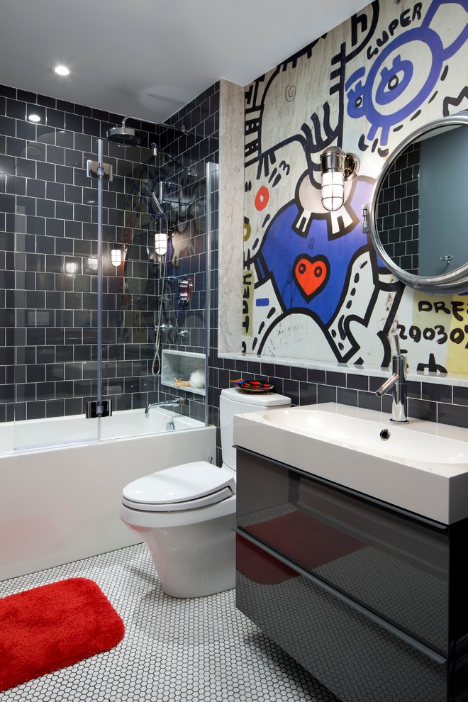 Bild på ett mellanstort funkis badrum för barn, med ett integrerad handfat, en dusch/badkar-kombination, svart kakel, flerfärgade väggar, släta luckor, grå skåp, ett badkar i en alkov, en toalettstol med separat cisternkåpa, porslinskakel och klinkergolv i porslin