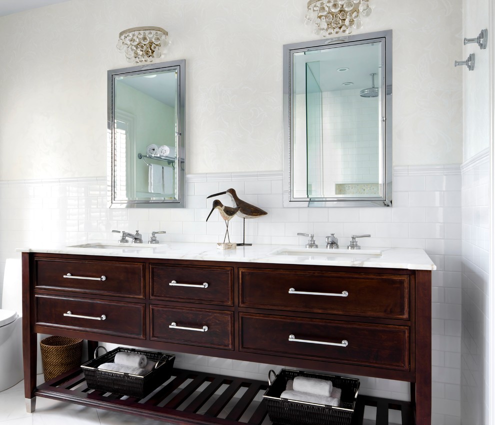 Inspiration for a large contemporary ensuite bathroom in Toronto with freestanding cabinets, dark wood cabinets, a freestanding bath, a corner shower, a one-piece toilet, white tiles, metro tiles, beige walls, marble flooring, a submerged sink and marble worktops.