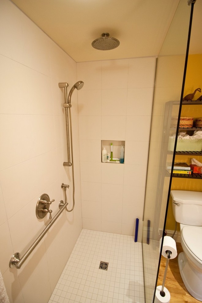 Ispirazione per una stanza da bagno padronale contemporanea di medie dimensioni con lavabo a consolle, ante in stile shaker, ante grigie, doccia a filo pavimento, WC monopezzo, piastrelle bianche, piastrelle in ceramica, pareti gialle e parquet chiaro