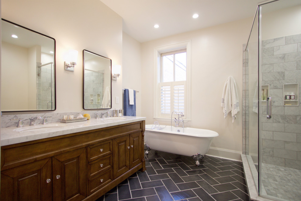 Example of a large transitional master gray tile and marble tile slate floor, black floor and double-sink bathroom design in Other with raised-panel cabinets, medium tone wood cabinets, white walls, an undermount sink, marble countertops, a hinged shower door, white countertops and a freestanding vanity