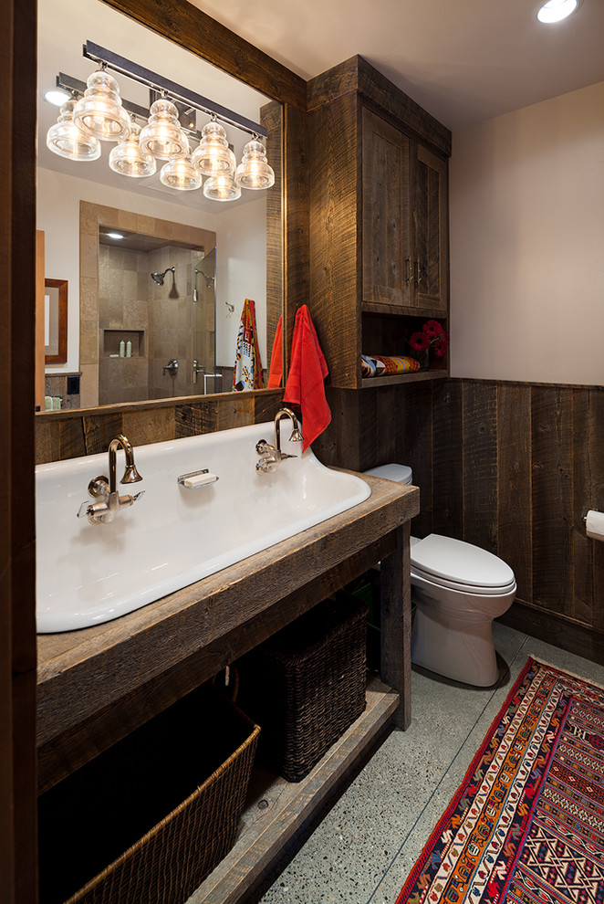 Idéer för rustika badrum med dusch, med öppna hyllor, skåp i mörkt trä, en dusch i en alkov, en toalettstol med separat cisternkåpa, brun kakel, porslinskakel, vita väggar, betonggolv, träbänkskiva och ett avlångt handfat