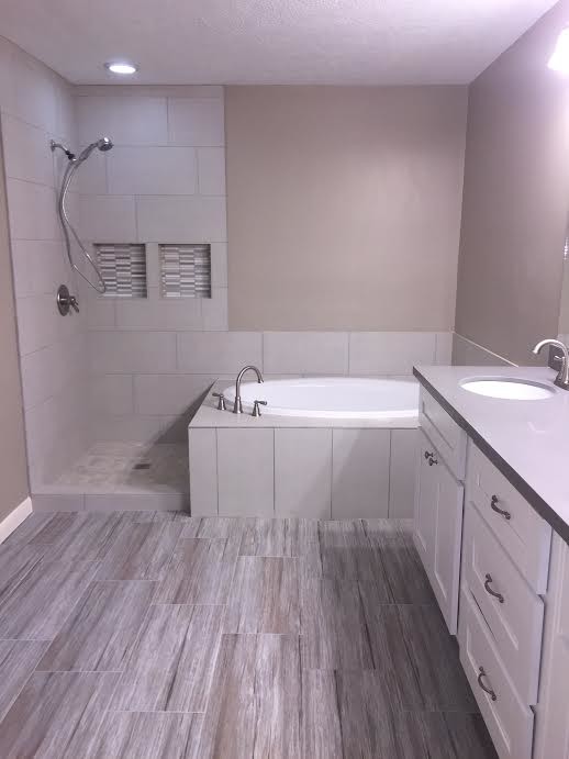Bathroom - large transitional master gray tile and porcelain tile porcelain tile bathroom idea in Houston with an undermount sink, shaker cabinets, white cabinets, solid surface countertops, a two-piece toilet and brown walls