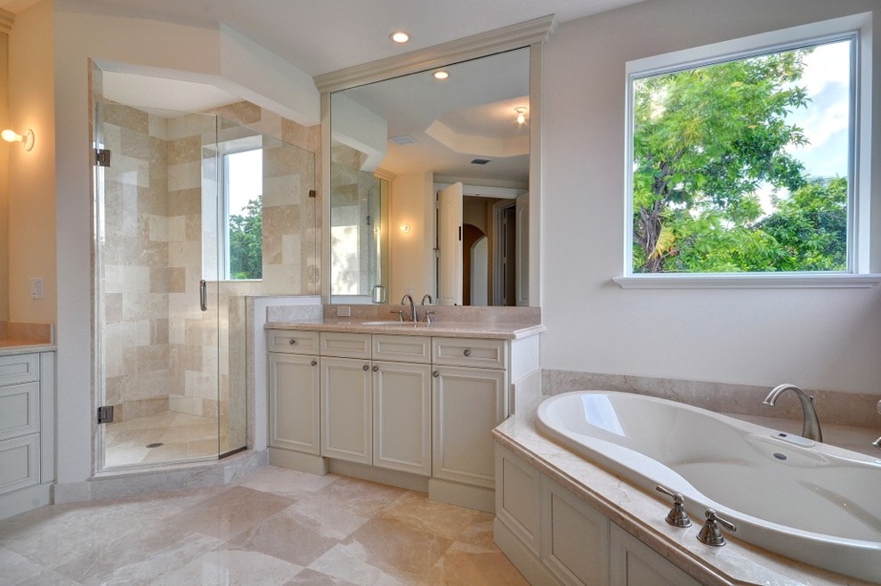 Inspiration pour une salle de bain principale traditionnelle de taille moyenne avec une douche d'angle, un placard avec porte à panneau encastré, des portes de placard blanches, une baignoire d'angle, un carrelage beige, un mur blanc, un sol en marbre, un lavabo encastré, un plan de toilette en marbre et du carrelage en marbre.