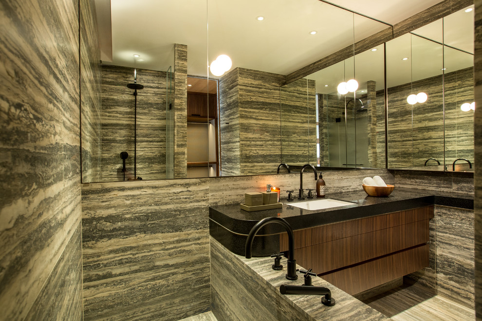 Inspiration för mellanstora amerikanska badrum, med skåp i mörkt trä, en dusch/badkar-kombination, blå kakel, stenhäll, svarta väggar, marmorgolv, ett nedsänkt handfat och marmorbänkskiva