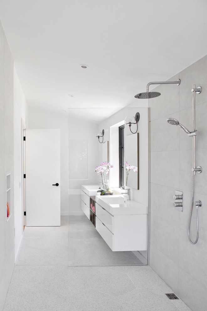 Свежая идея для дизайна: ванная комната в современном стиле с плоскими фасадами, белыми фасадами, душем без бортиков, серой плиткой, белыми стенами, монолитной раковиной, серым полом, открытым душем и белой столешницей - отличное фото интерьера