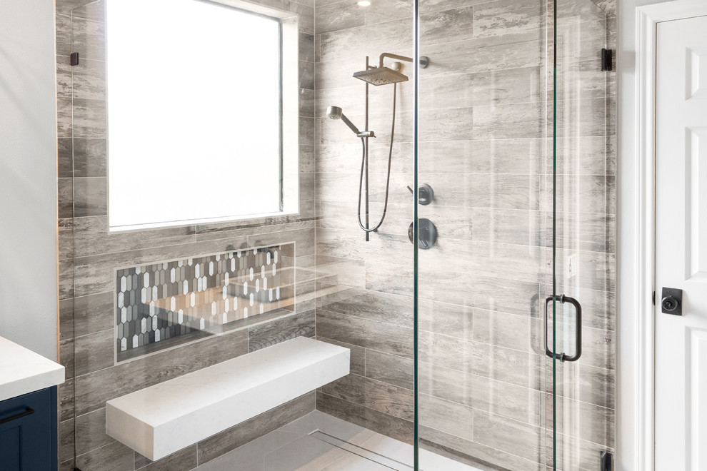 Design ideas for a medium sized modern ensuite bathroom in Houston with recessed-panel cabinets, blue cabinets, a built-in shower, a two-piece toilet, grey tiles, ceramic tiles, grey walls, porcelain flooring, a vessel sink, engineered stone worktops, grey floors, an open shower and white worktops.