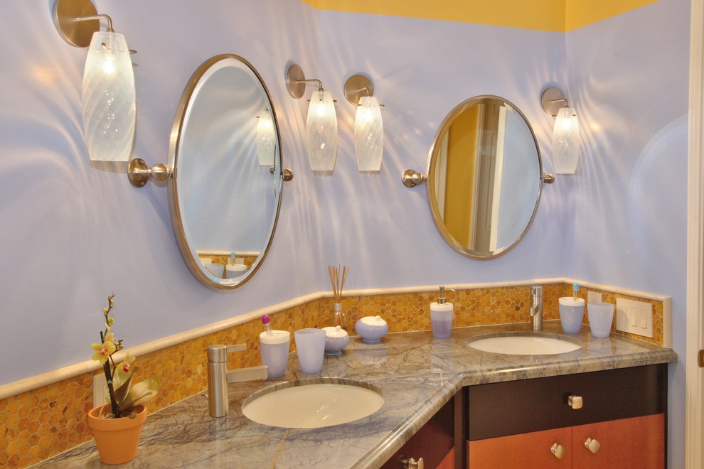 Cette image montre une salle de bain design en bois brun avec un lavabo encastré, un placard à porte plane, un carrelage beige, mosaïque, un plan de toilette en granite, un mur violet et un sol en marbre.