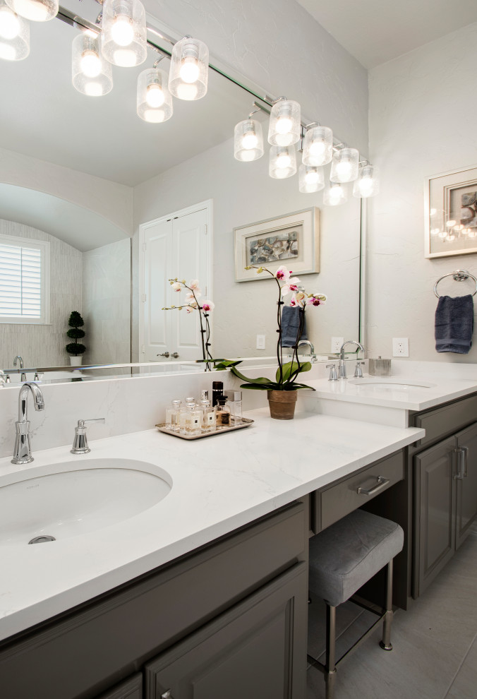 Example of a mid-sized transitional master gray tile and porcelain tile porcelain tile, gray floor and double-sink bathroom design in Dallas with raised-panel cabinets, gray cabinets, a two-piece toilet, gray walls, an undermount sink, quartz countertops, a hinged shower door, white countertops and a built-in vanity