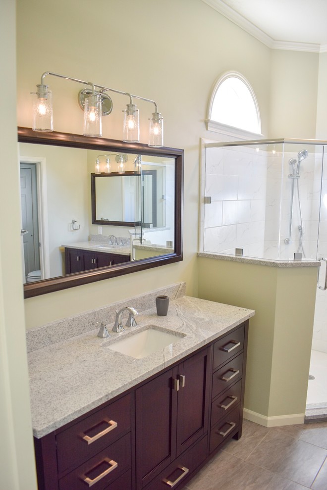 Пример оригинального дизайна: огромная главная ванная комната в стиле неоклассика (современная классика) с фасадами в стиле шейкер, темными деревянными фасадами, угловым душем, белой плиткой, керамогранитной плиткой, зелеными стенами, полом из керамогранита, врезной раковиной, столешницей из гранита, серым полом и душем с распашными дверями