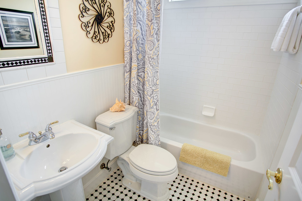 Bild på ett litet vintage badrum med dusch, med vit kakel, ett badkar i en alkov, en dusch/badkar-kombination, en toalettstol med hel cisternkåpa, tunnelbanekakel, gula väggar, mosaikgolv, ett piedestal handfat, vitt golv och dusch med duschdraperi