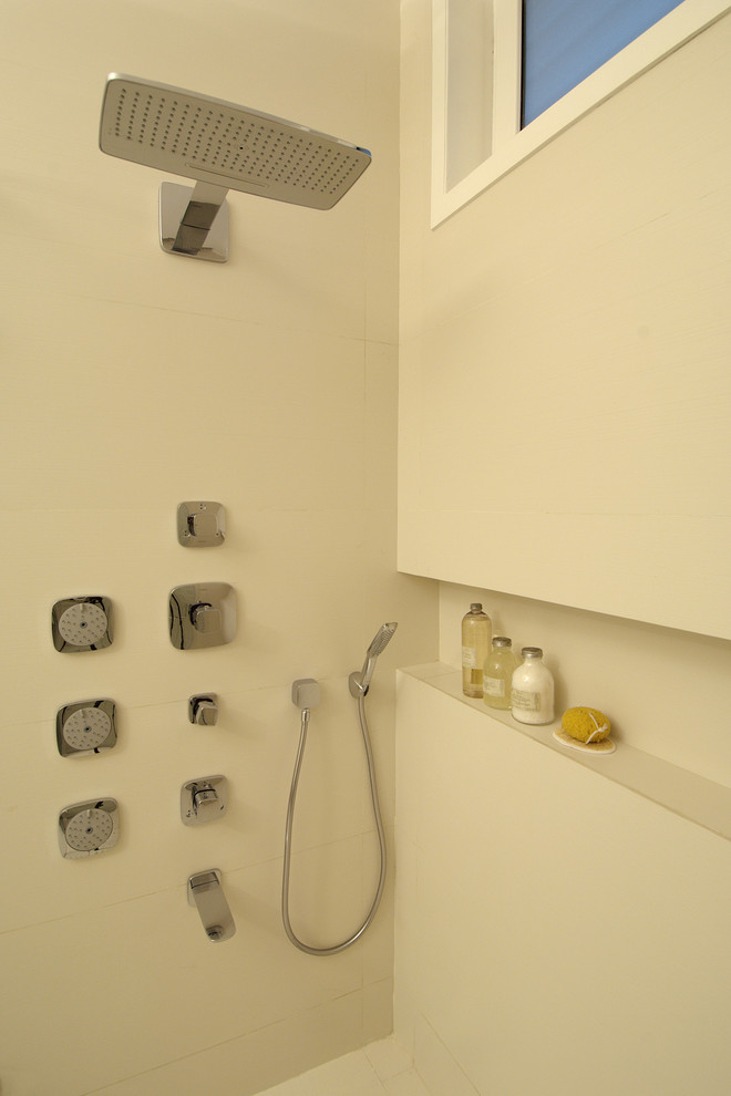 Modern inredning av ett mellanstort badrum, med möbel-liknande, skåp i mellenmörkt trä, en kantlös dusch, en vägghängd toalettstol, vit kakel, porslinskakel, vita väggar, klinkergolv i porslin och ett integrerad handfat