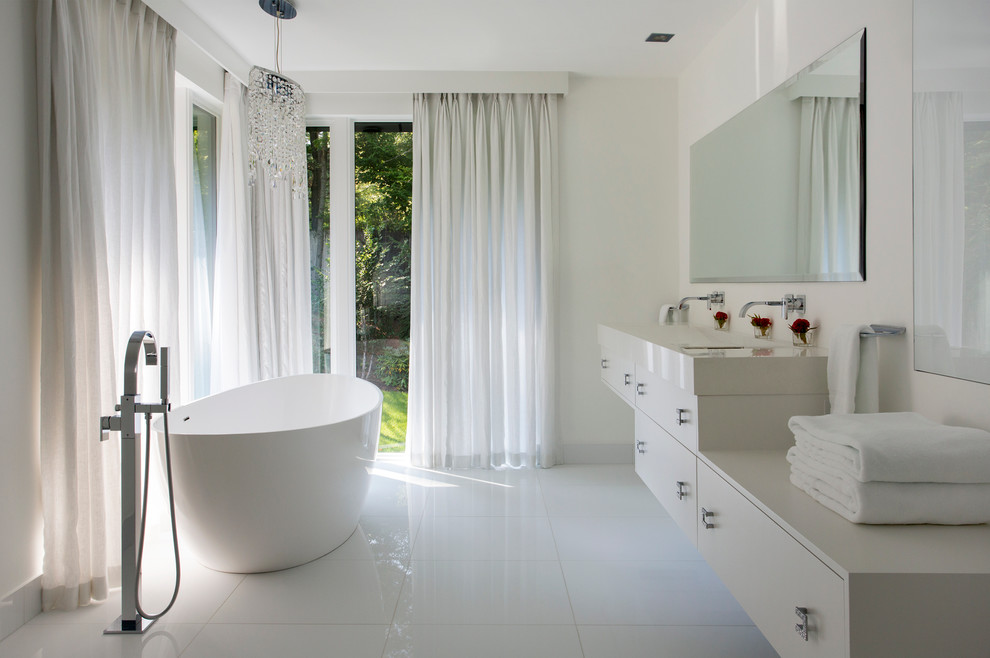 Imagen de cuarto de baño principal moderno de tamaño medio con bañera exenta, ducha abierta, baldosas y/o azulejos blancos, paredes blancas y lavabo integrado
