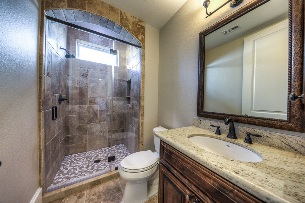 This is an example of a small traditional shower room bathroom in Houston with beaded cabinets, dark wood cabinets, an alcove shower, a two-piece toilet, beige tiles, brown tiles, mosaic tiles, brown walls, ceramic flooring, a submerged sink and granite worktops.