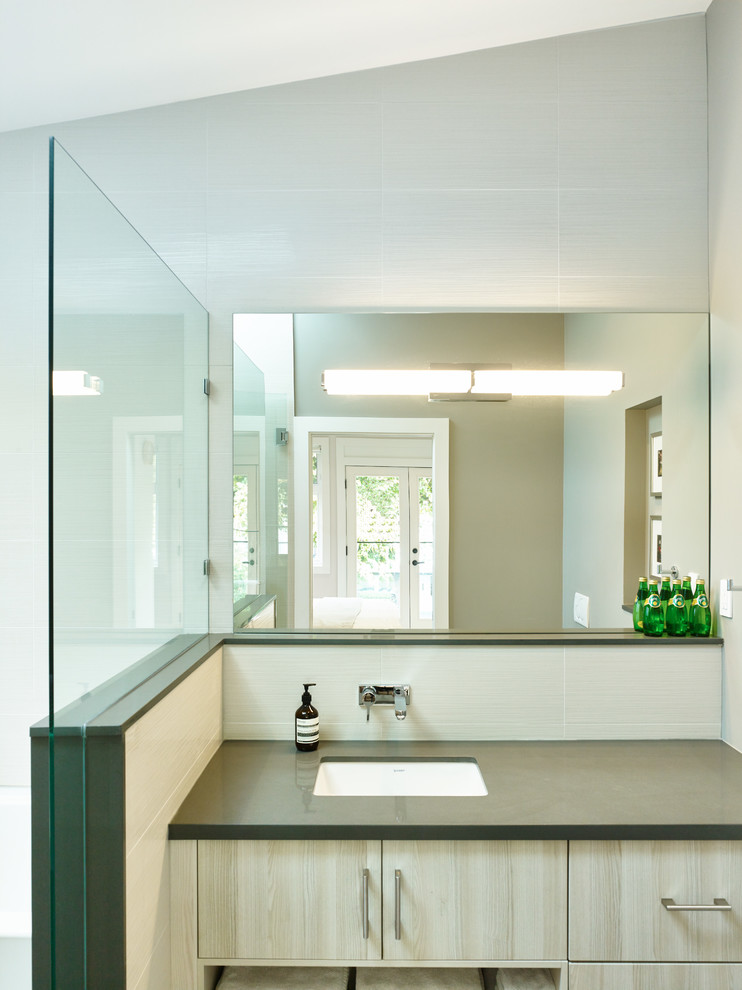 Inspiration for a contemporary white tile and ceramic tile ceramic tile bathroom remodel in Vancouver with an undermount sink, flat-panel cabinets, light wood cabinets, granite countertops, a wall-mount toilet and gray walls