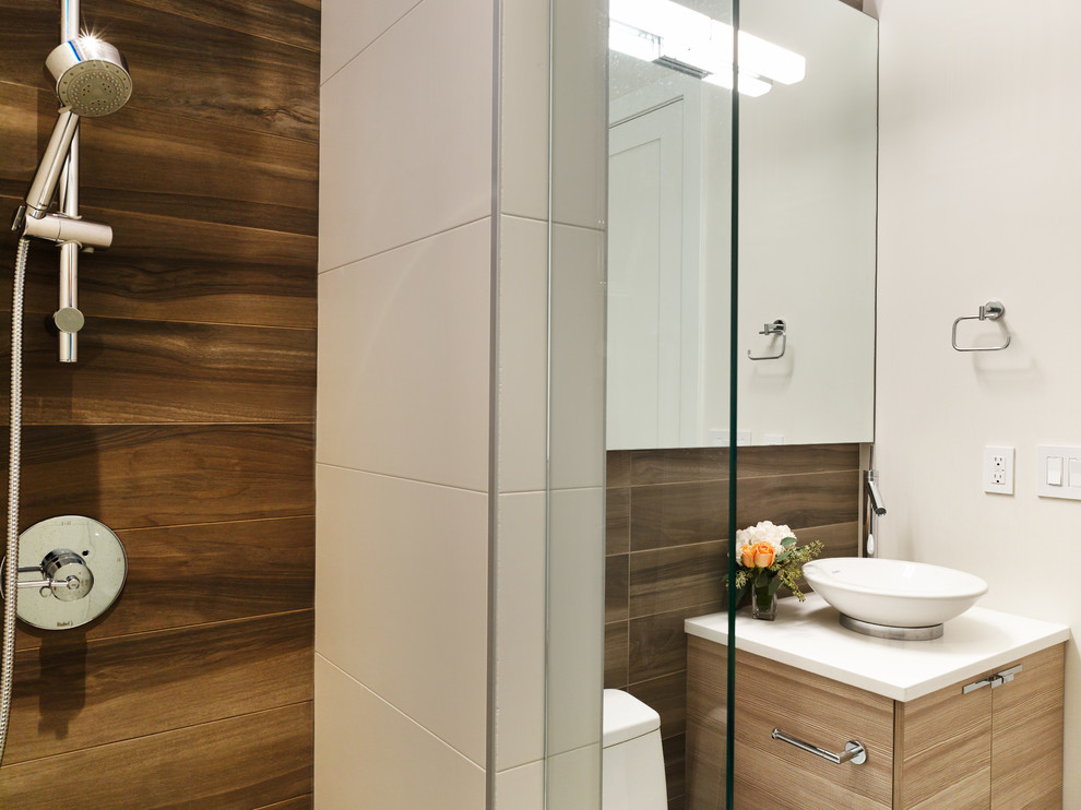 Example of a trendy brown tile and ceramic tile ceramic tile bathroom design in Vancouver with a vessel sink, light wood cabinets, quartz countertops, a one-piece toilet and beige walls