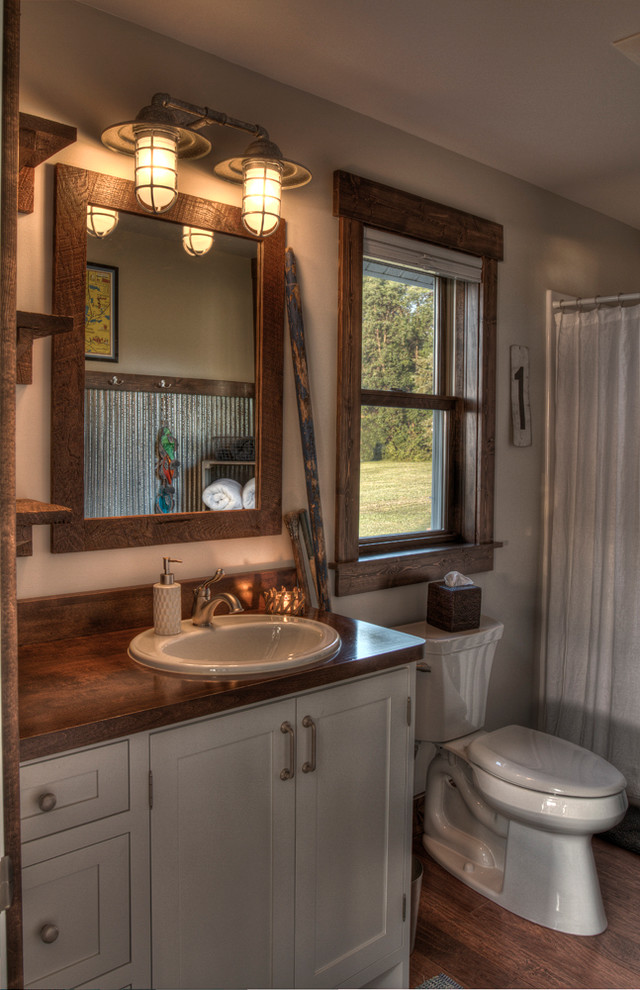 Idéer för mellanstora vintage badrum med dusch, med luckor med profilerade fronter, grå skåp, en dusch i en alkov, en toalettstol med separat cisternkåpa, grå väggar, mellanmörkt trägolv, ett nedsänkt handfat, träbänkskiva, brunt golv och dusch med duschdraperi