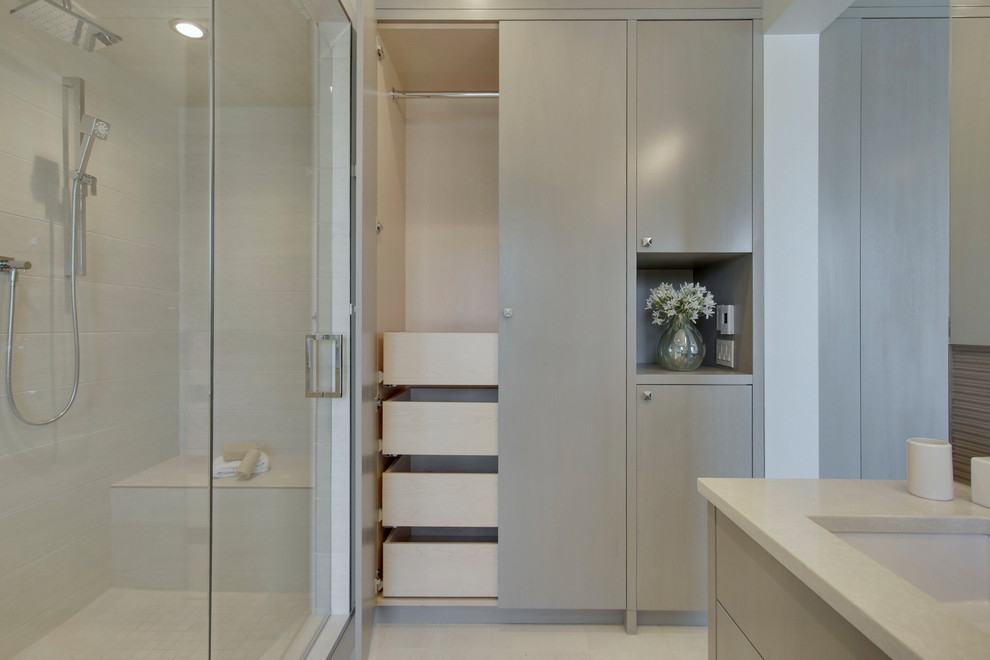Стильный дизайн: главная ванная комната среднего размера в современном стиле с плоскими фасадами, серыми фасадами, угловым душем, унитазом-моноблоком, серой плиткой, стеклянной плиткой, серыми стенами, полом из керамогранита, врезной раковиной, столешницей из искусственного кварца, белым полом и душем с распашными дверями - последний тренд