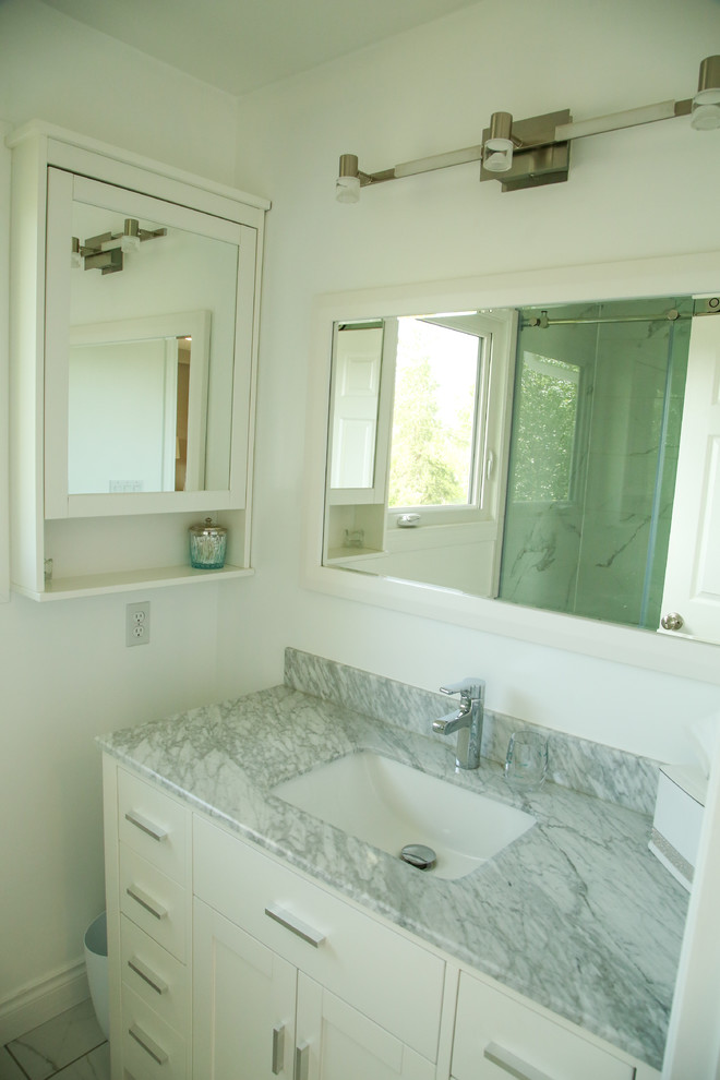 Idéer för mellanstora vintage en-suite badrum, med släta luckor, vita skåp, en dusch i en alkov, en toalettstol med separat cisternkåpa, marmorkakel, vita väggar, marmorgolv, ett undermonterad handfat, marmorbänkskiva, vitt golv och dusch med skjutdörr