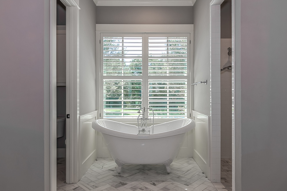 Foto de cuarto de baño principal contemporáneo de tamaño medio con bañera con patas, baldosas y/o azulejos blancos, paredes grises y suelo de mármol