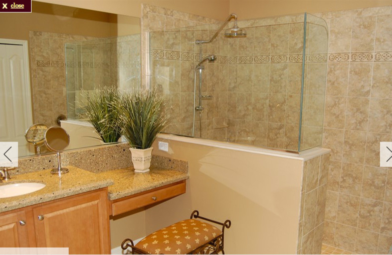 This is an example of a large traditional ensuite bathroom in Tampa with raised-panel cabinets, light wood cabinets, a corner bath, a walk-in shower, beige tiles, porcelain tiles and engineered stone worktops.