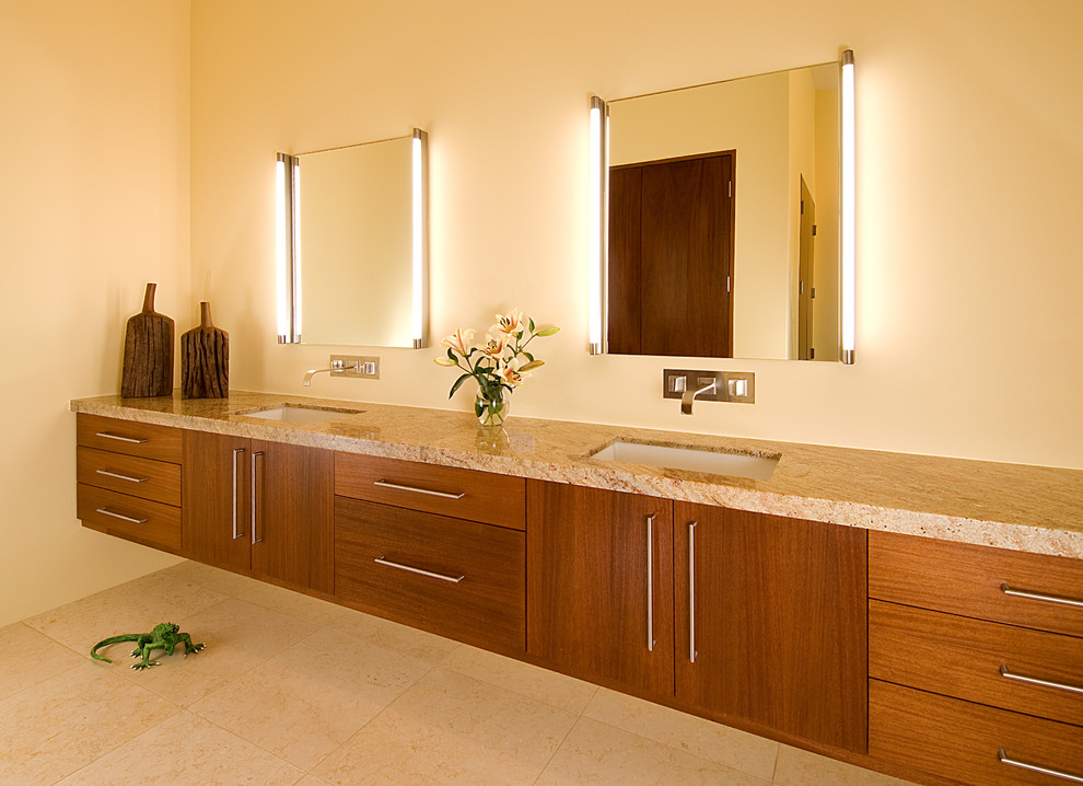 Idee per un'ampia stanza da bagno padronale contemporanea con ante lisce, ante in legno scuro, pareti gialle, pavimento in pietra calcarea, lavabo sottopiano, top in granito, pavimento beige e top beige