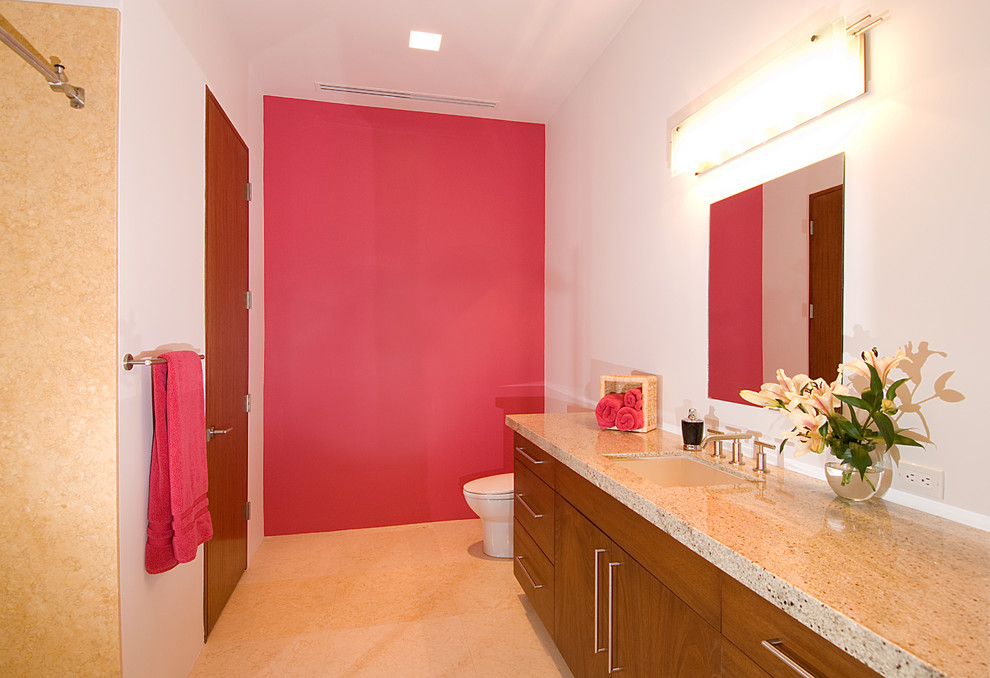 Источник вдохновения для домашнего уюта: большая ванная комната в современном стиле с плоскими фасадами, фасадами цвета дерева среднего тона, душем в нише, унитазом-моноблоком, бежевой плиткой, мраморной плиткой, розовыми стенами, полом из известняка, душевой кабиной, врезной раковиной, столешницей из гранита, бежевым полом, душем с раздвижными дверями и бежевой столешницей