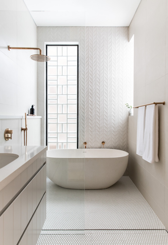 Exempel på ett mellanstort modernt beige beige en-suite badrum, med släta luckor, grå skåp, ett fristående badkar, våtrum, vit kakel, porslinskakel, klinkergolv i porslin, ett undermonterad handfat, vitt golv och med dusch som är öppen