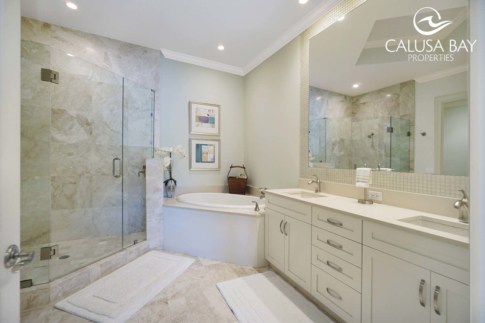 На фото: главная ванная комната в морском стиле с угловой ванной, угловым душем и монолитной раковиной