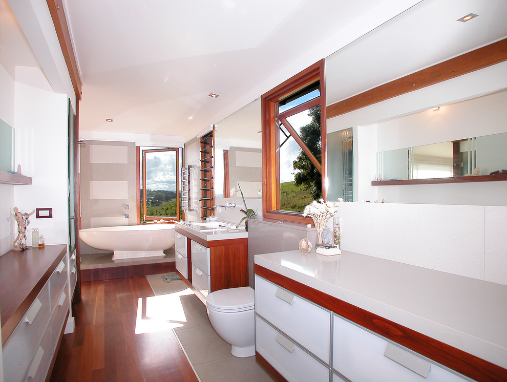 Cette photo montre une salle de bain tendance avec une baignoire indépendante et un plan de toilette en bois.
