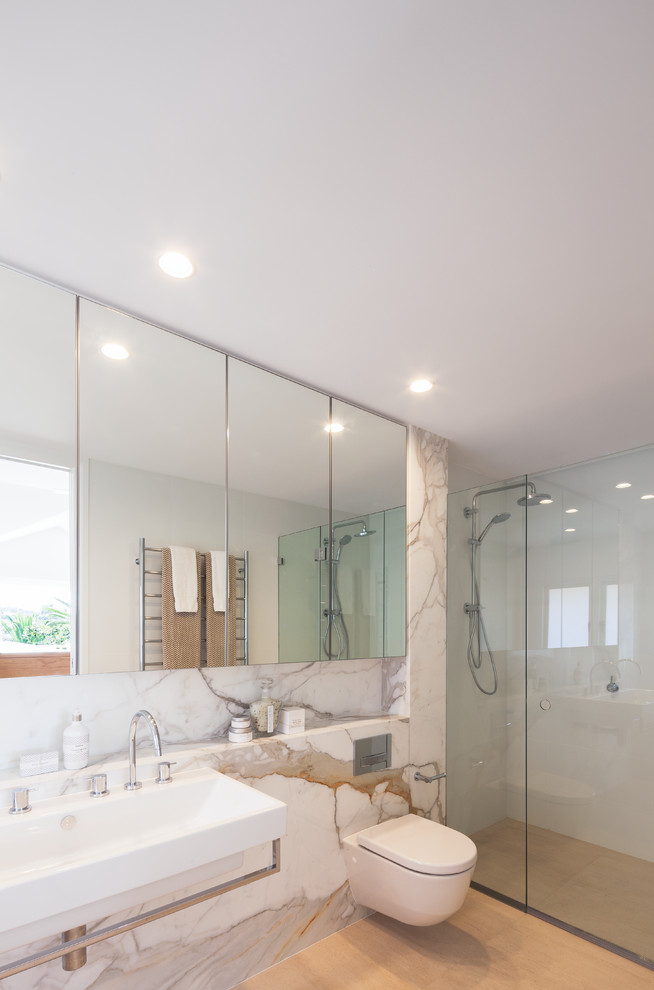 Idées déco pour une salle de bain scandinave avec un plan de toilette en marbre, WC suspendus et parquet clair.