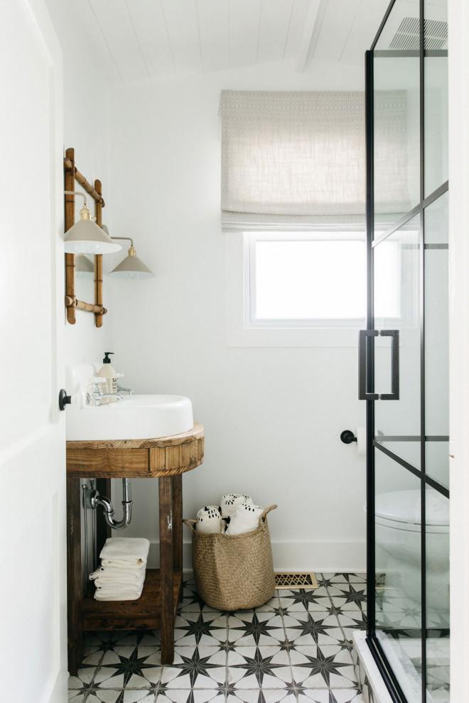 Cette image montre une salle de bain marine en bois brun avec un mur blanc, une vasque, un sol multicolore, du carrelage bicolore et un placard sans porte.