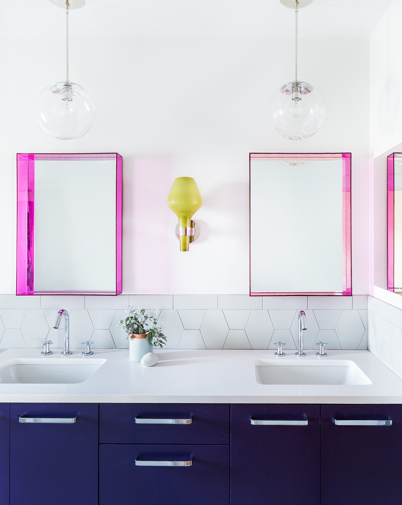 Ejemplo de cuarto de baño actual con armarios con paneles lisos, puertas de armario azules, baldosas y/o azulejos blancos, paredes blancas, lavabo bajoencimera y encimeras blancas