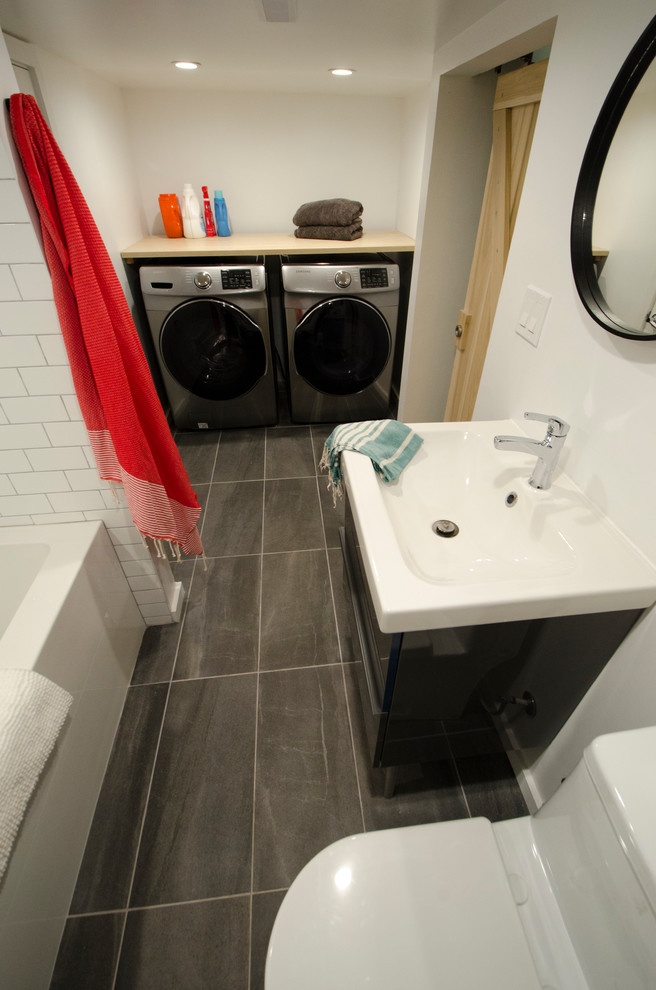 Idéer för att renovera ett mellanstort funkis vit vitt badrum, med släta luckor, grå skåp, ett badkar i en alkov, en dusch/badkar-kombination, en toalettstol med separat cisternkåpa, vit kakel, tunnelbanekakel, vita väggar, klinkergolv i porslin, ett integrerad handfat, bänkskiva i akrylsten, grått golv och dusch med duschdraperi