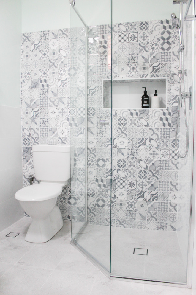 Small minimalist 3/4 multicolored tile and mosaic tile porcelain tile, white floor and single-sink corner shower photo in Perth with shaker cabinets, white cabinets, a one-piece toilet, white walls, an integrated sink, quartz countertops, a hinged shower door, white countertops and a floating vanity