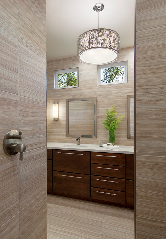 Cette photo montre une salle de bain principale tendance en bois brun de taille moyenne avec un placard à porte plane, une douche à l'italienne, un carrelage beige, des carreaux de céramique, un mur beige, un sol en carrelage de céramique, un lavabo encastré et un plan de toilette en surface solide.