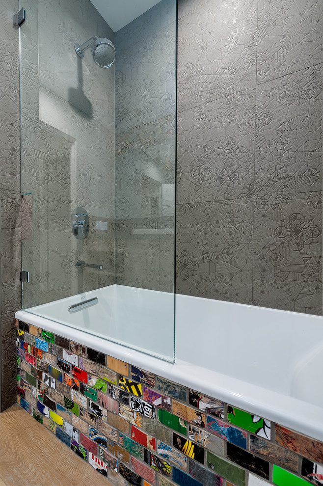 Bild på ett stort funkis badrum med dusch, med ett badkar i en alkov, flerfärgad kakel, tunnelbanekakel, ett fristående handfat, grå skåp, bänkskiva i kvarts, en dusch/badkar-kombination, en toalettstol med hel cisternkåpa, grå väggar, mellanmörkt trägolv, brunt golv och dusch med skjutdörr