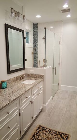 Foto på ett vintage en-suite badrum, med luckor med infälld panel, vita skåp, en kantlös dusch, kakel i småsten, vita väggar, klinkergolv i porslin, ett undermonterad handfat och granitbänkskiva