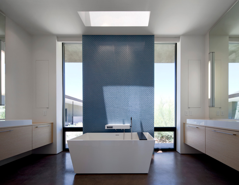 Inspiration för ett funkis badrum, med ett fristående handfat, släta luckor, skåp i ljust trä, ett fristående badkar, blå kakel, mosaik, vita väggar och betonggolv