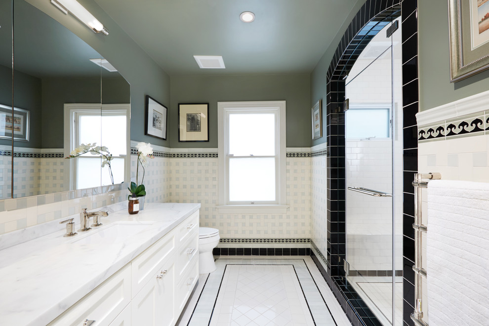 Example of a large classic master white tile and ceramic tile ceramic tile and white floor alcove shower design in San Diego with shaker cabinets, white cabinets, a two-piece toilet, green walls, an undermount sink, marble countertops and a hinged shower door