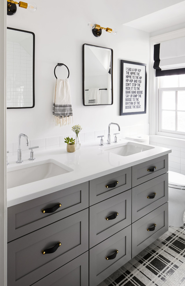 Klassisk inredning av ett vit vitt badrum, med skåp i shakerstil, grå skåp, vit kakel, tunnelbanekakel, vita väggar, ett undermonterad handfat och flerfärgat golv