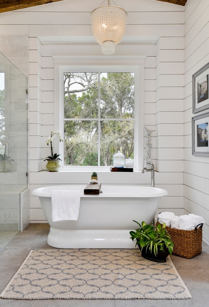 На фото: главная ванная комната в стиле рустика с отдельно стоящей ванной, белыми стенами и серым полом