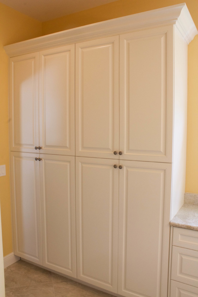 Inredning av ett klassiskt litet en-suite badrum, med ett undermonterad handfat, luckor med upphöjd panel, vita skåp, granitbänkskiva, gula väggar, klinkergolv i porslin och grå kakel