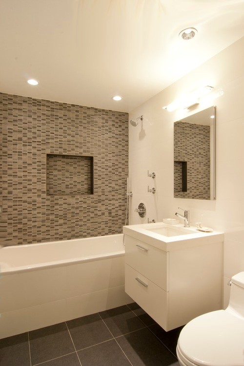 Exempel på ett litet modernt en-suite badrum, med klinkergolv i keramik, vita skåp, en toalettstol med hel cisternkåpa, bänkskiva i kvarts, släta luckor, ett badkar i en alkov, en dusch/badkar-kombination, grå kakel, porslinskakel, grå väggar, ett undermonterad handfat, grått golv och dusch med duschdraperi