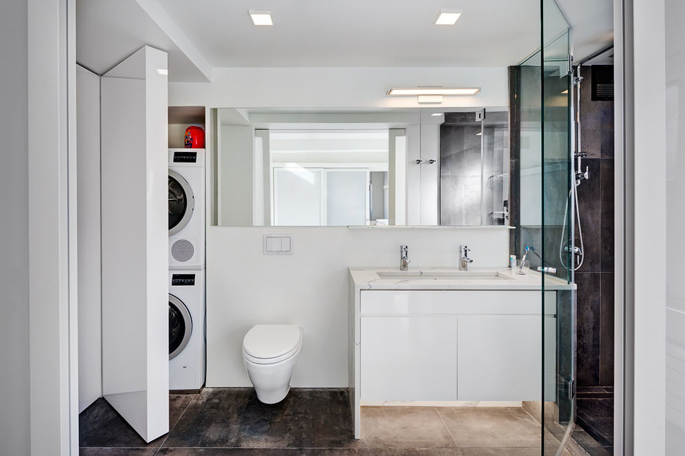 Photo of a medium sized modern bathroom in New York with flat-panel cabinets, white cabinets, an alcove shower, a wall mounted toilet, white walls, a submerged sink, marble worktops, black tiles, cement tiles and cement flooring.